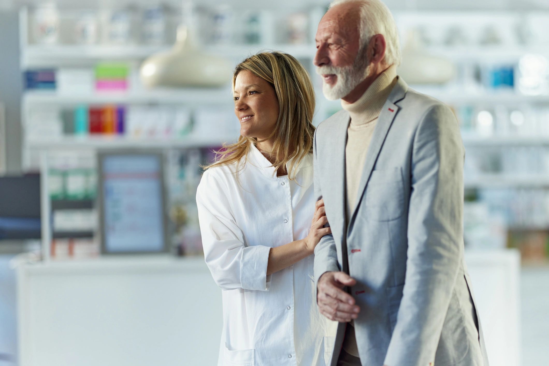 Female pharmacist assisting an elderly man in a pharmacy