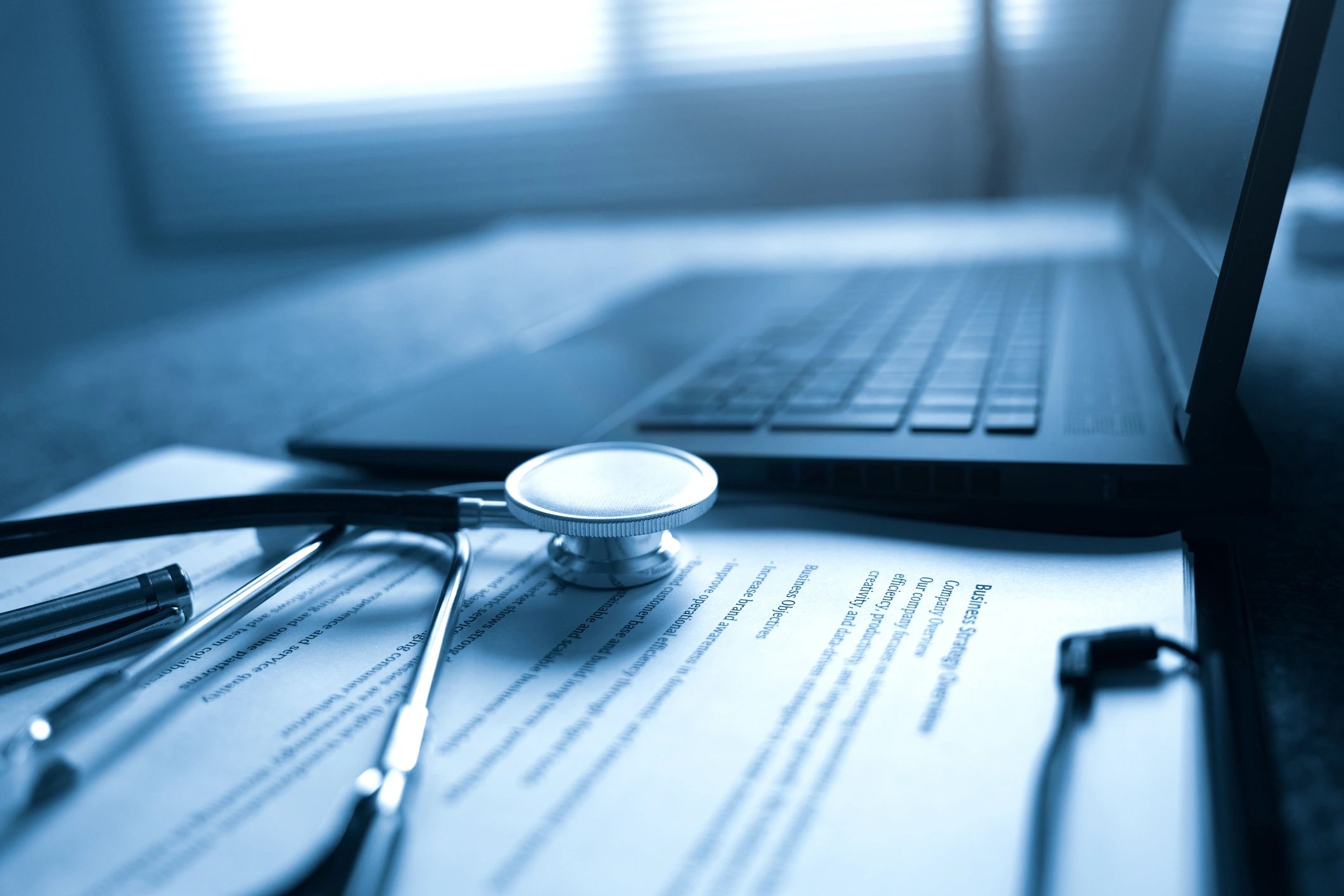 Healthcare paperwork and laptop on a desk